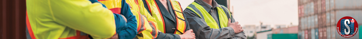 Workers wearing high-visibility vests and safety gear standing with arms crossed at an industrial site, representing Skookum Tools' general safety wear and protective equipment category.